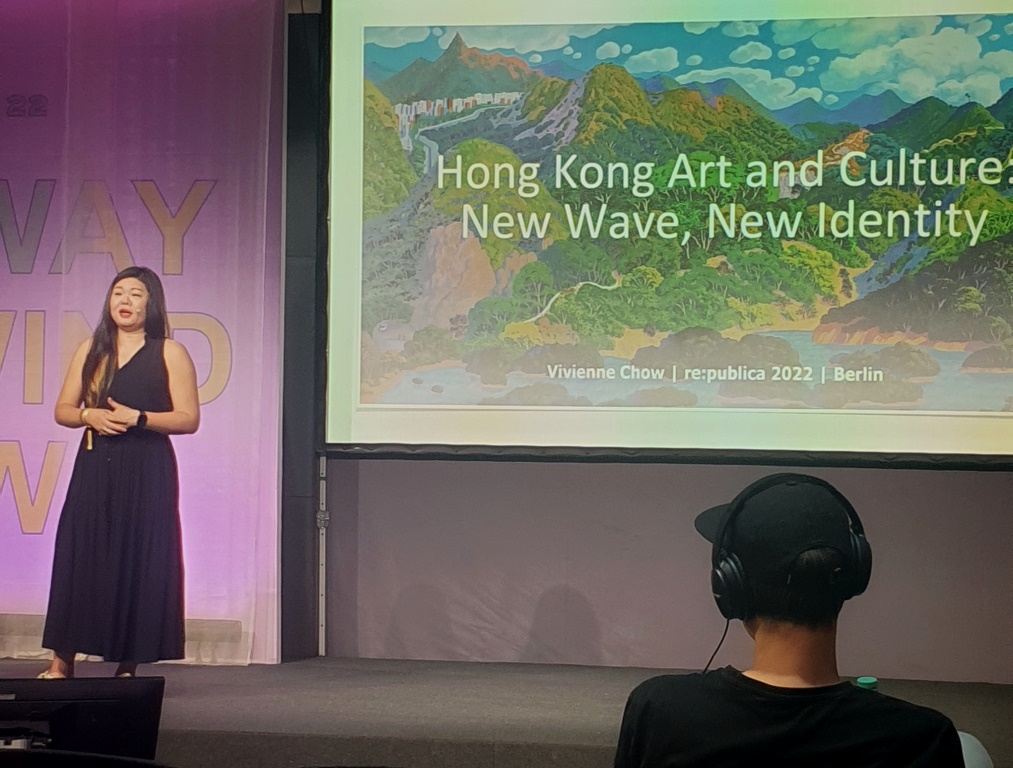 Ein Frau, Vivienne Chow, vor der Folie mit der Aufschrift "Hong Kong Art and Culture. New Wave, New Identity"