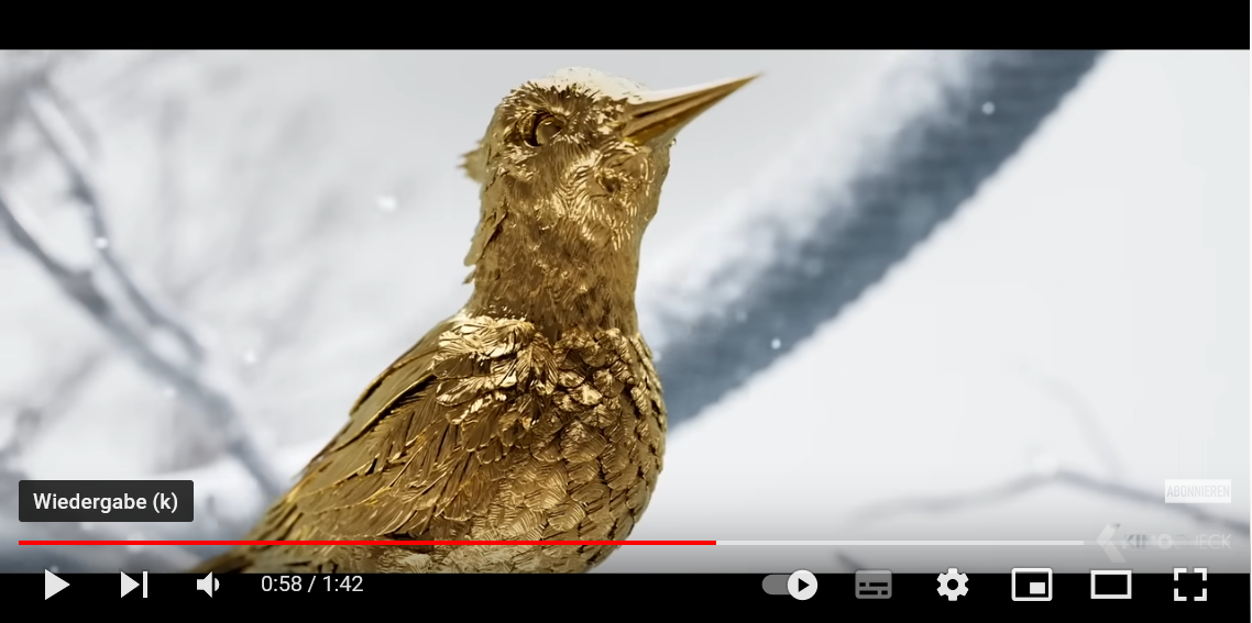 Screenshot aus dem "Panem X"-Teaser, zeigt einen goldenen Vogel. Ein Klick führt auf YouTube.