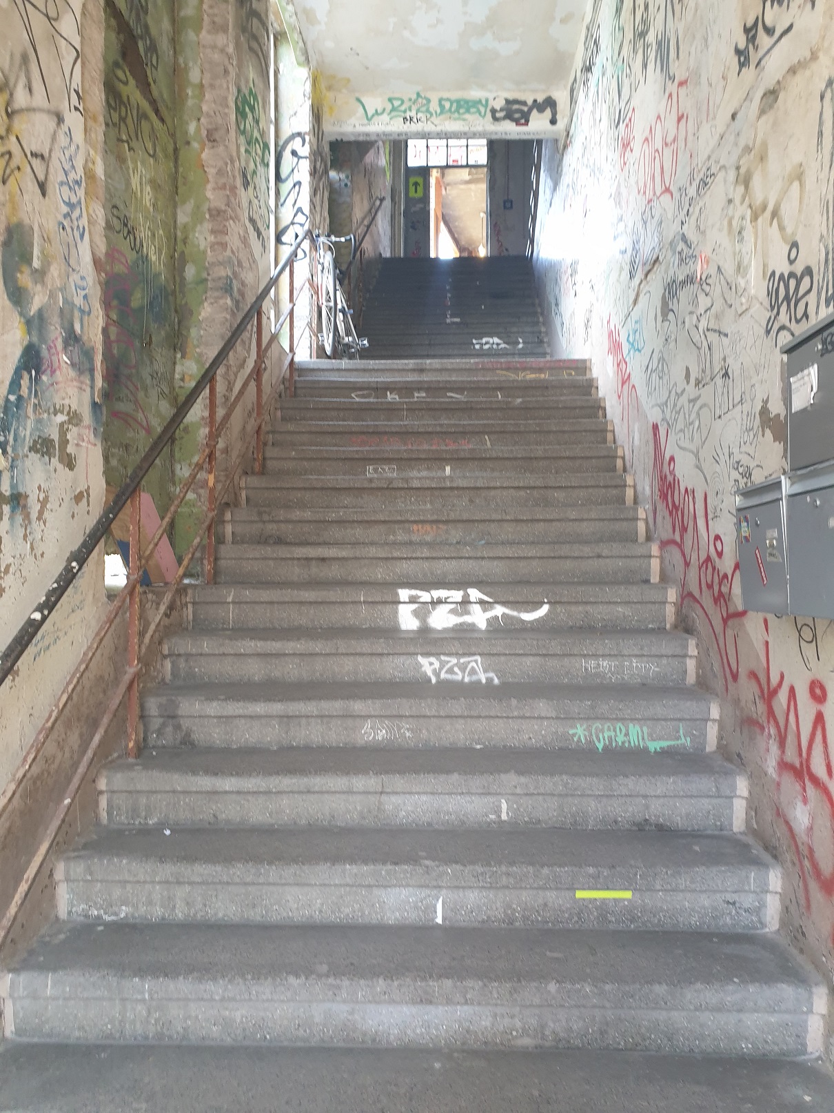 eine Treppe nach oben mit Graffiti-reichen Betonwänden