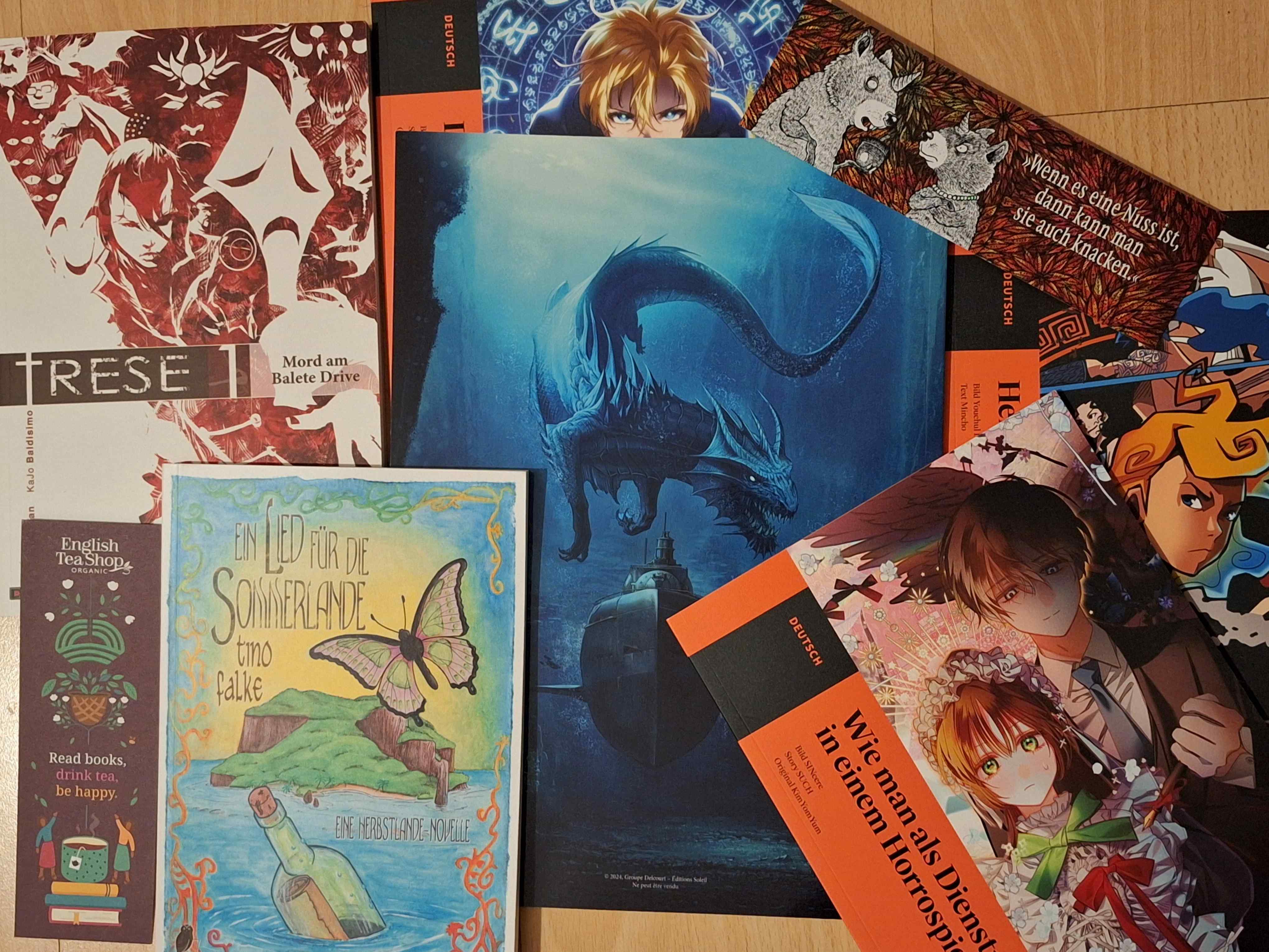 Sammlung von Mangas, Comics, Lesezeichen und dem Roman "Ein Lied für die Sommerlande"