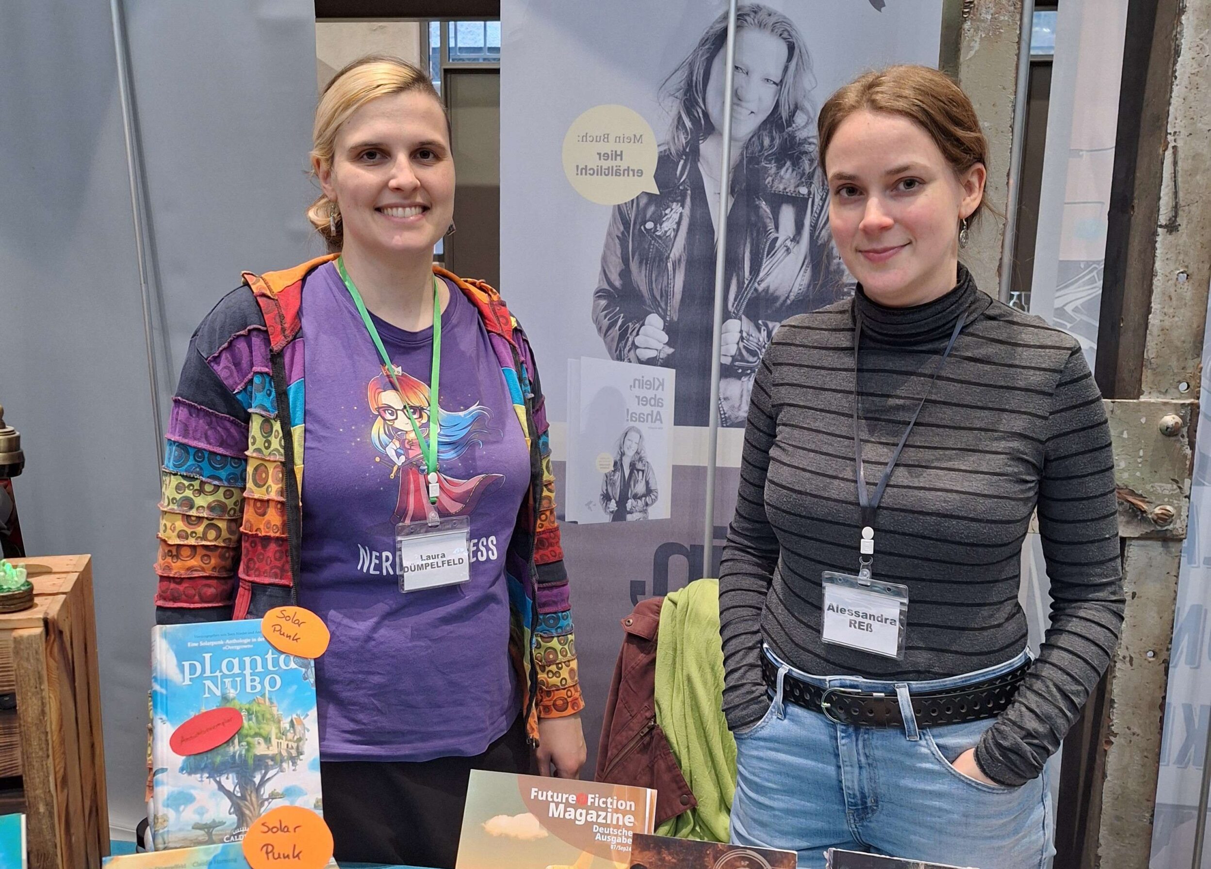 Laura Dümpelfeld (weiße Frau mit braunblonden Haaren und bunter Kleidung) und Alessandra Reß (weiße Frau mit dunklem Rollkragenpulli und dunkelblonden Haaren)