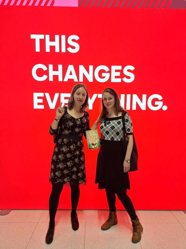 Hannah Brosch und Alessandra Reß mit "in Bernstein gebannt" vor einem Bildschirm mit der Aufschrift "This Changes Everything"